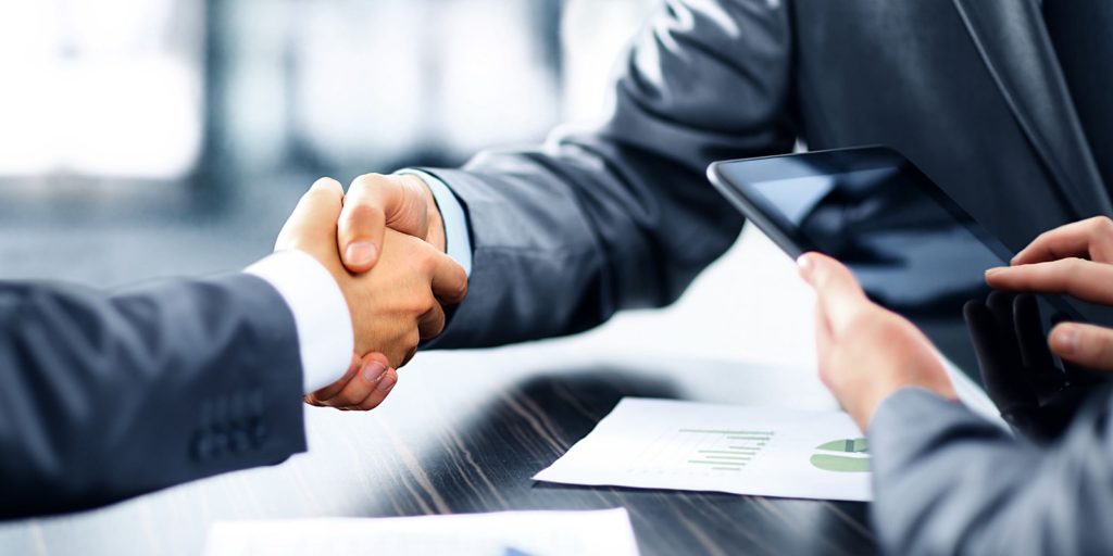 a handshake to close an insurance marketing services contract