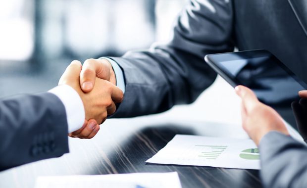 a handshake to close an insurance marketing services contract