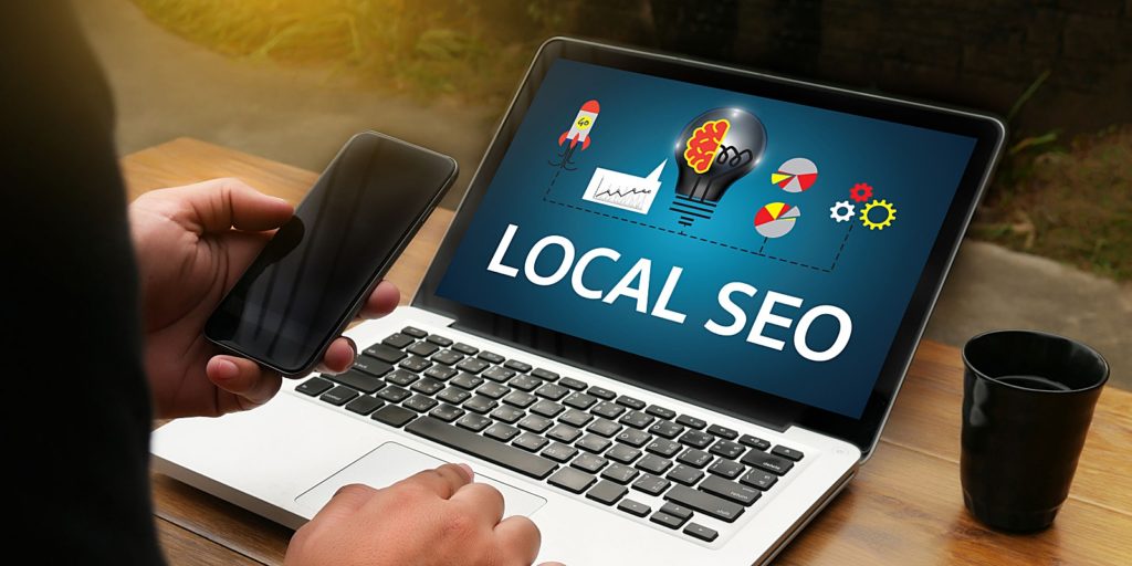 a slideshow describing local SEO on a laptop computer that a digital marketing agency is showing to the owner of a local business