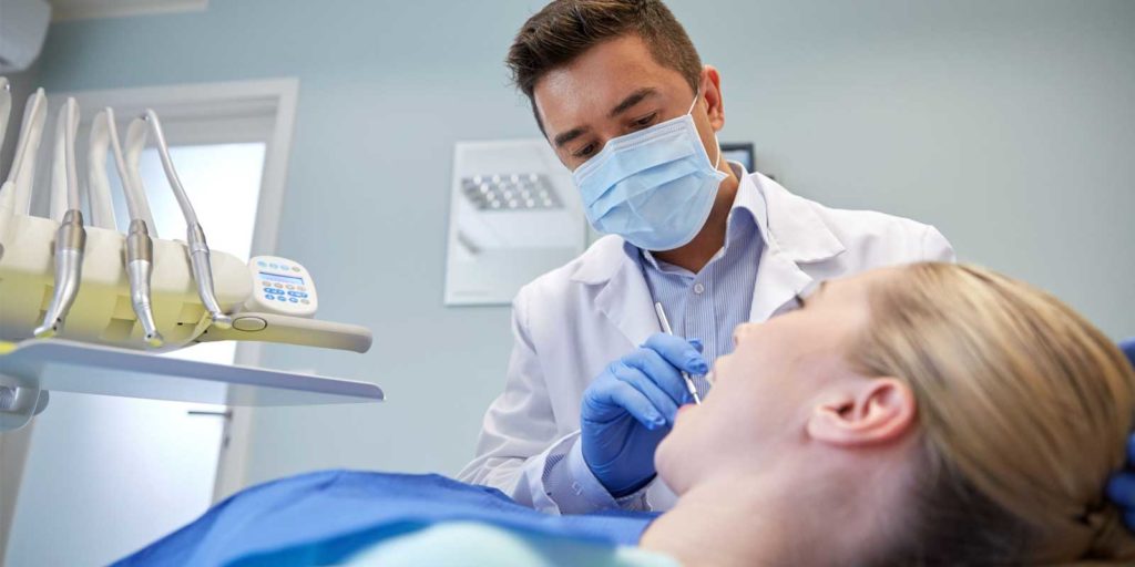 a dentist servicing a new patient who found his practice through good dental SEO marketing employed by a trusted dental marketing agency