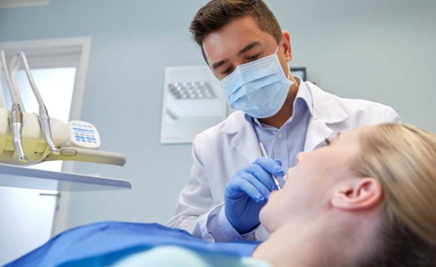 a dentist servicing a new patient who found his practice through good dental SEO marketing employed by a trusted dental marketing agency