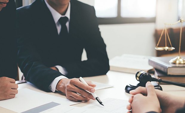 an attorney signing a document with a law firm marketing agency to discuss how digital marketing will be beneficial to his firm and book of clients