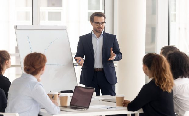 Male business coach speaker in suit give flipchart presentation