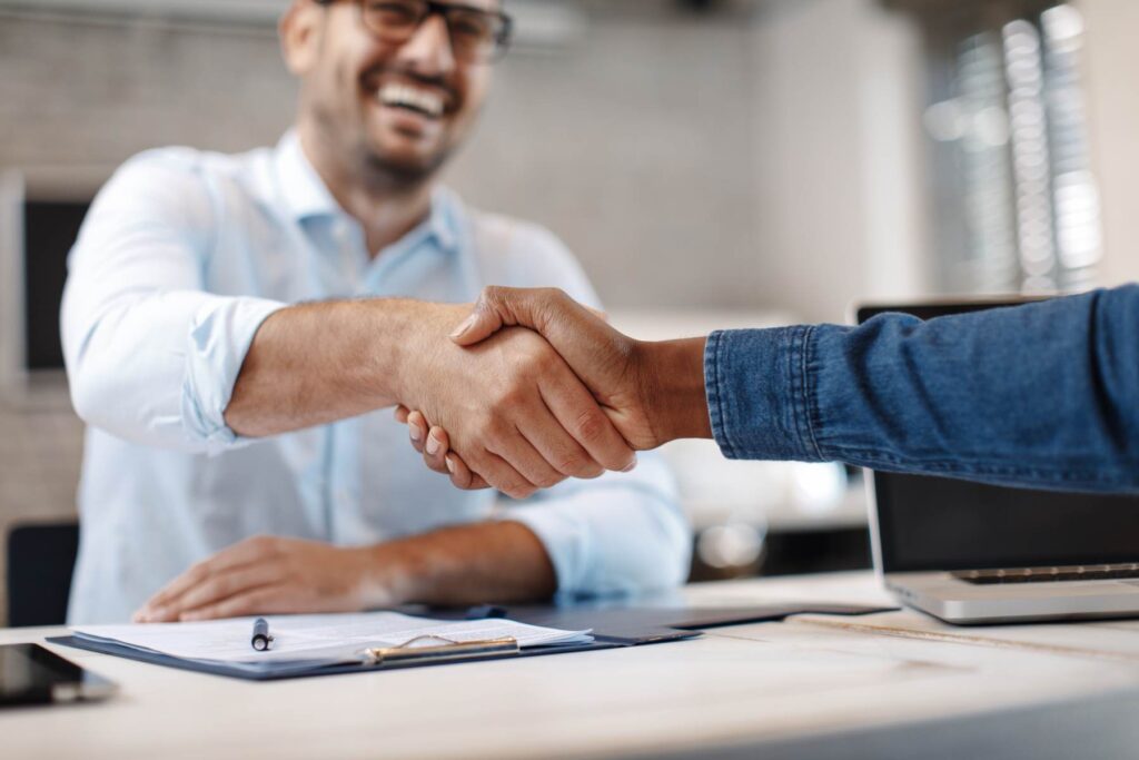 Insurance agent shaking digital marketer hand
