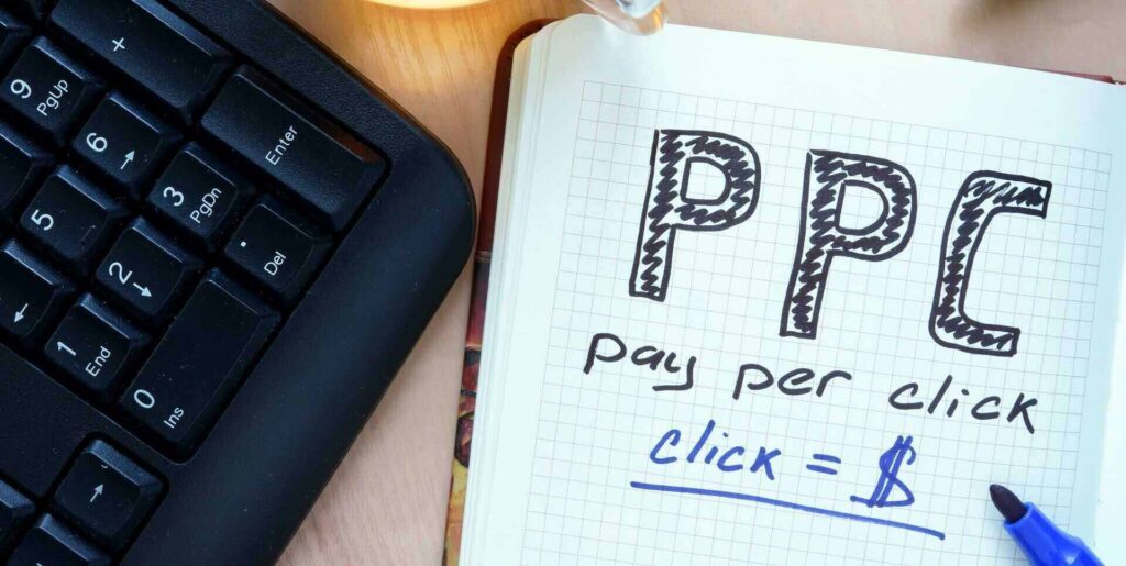 notepad with words ppc pay per click concept and marker