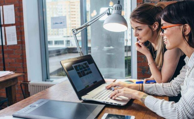 women working on new website design choosing pictures using the laptop surfing the internet